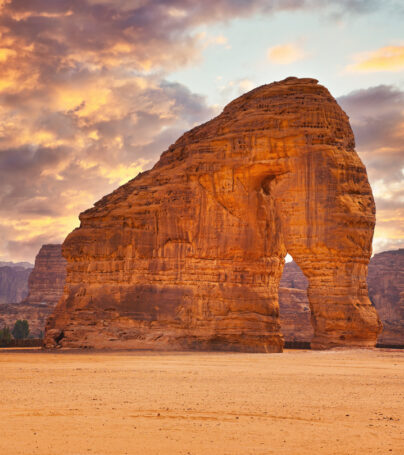 Jabal AlFil - Elephant Rock in Al Ula desert landscape, dramatic sunset sky above - Saudi Arabia