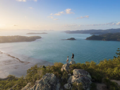 Couple enjoying the view on top mountain overlooking Whitsundays ocean